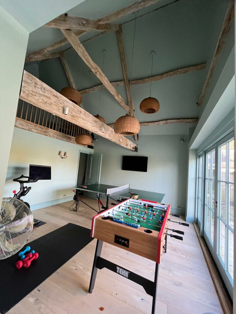 games room with vaulted ceiling and wooden beams